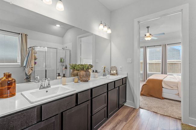 Bathroom featuring plenty of natural light, double vanity, a shower stall, light wood-type flooring, and recessed lighting | Image 25