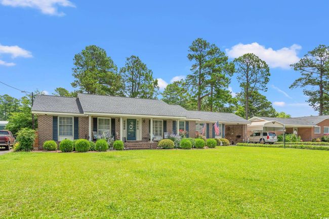 Ranch-style house featuring a front lawn, brick siding, and a detached carport | Image 18