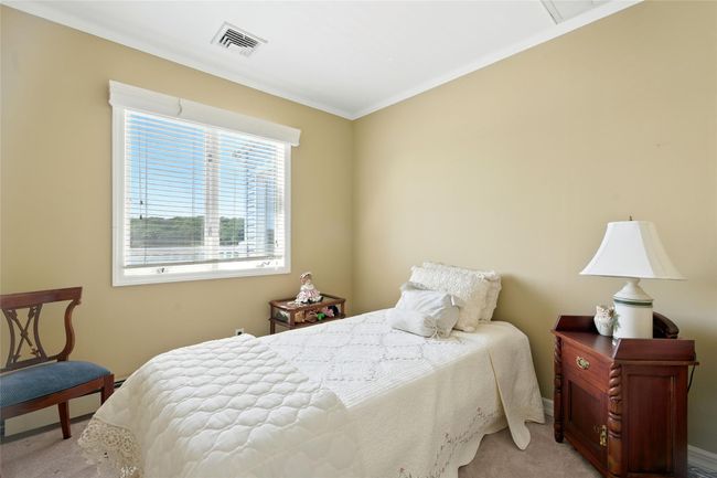 Bedroom with light colored carpet and ornamental molding | Image 31
