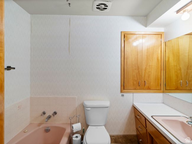 Full bathroom with a garden tub, vanity, toilet, and wallpapered walls | Image 18