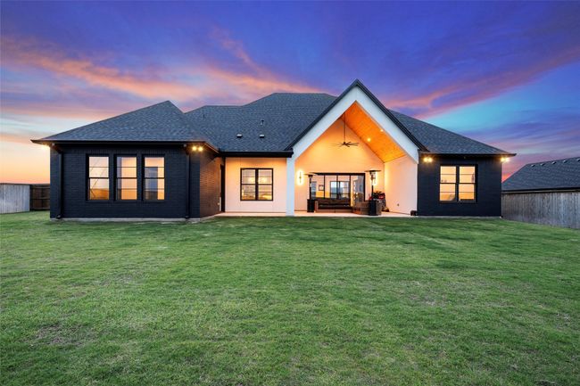 Back of property with a lawn, ceiling fan, a shingled roof, and a patio area | Image 38