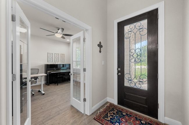 Entryway with french doors, light wood-type flooring, and ceiling fan leading to office with french doors | Image 18