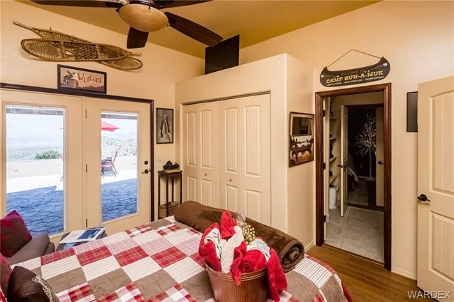 Bedroom with access to exterior, wood finished floors, a closet, lofted ceiling, and ceiling fan | Image 72