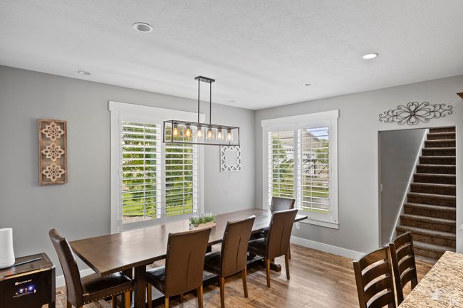 Dining space featuring wood finished floors, stairway, baseboards, and recessed lighting | Image 23