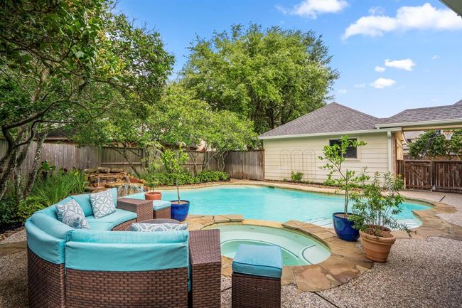 The private backyard offers lots of established landscaping, a sparkling pool and spa as well as a calming rock waterfall for ambiance. | Image 37