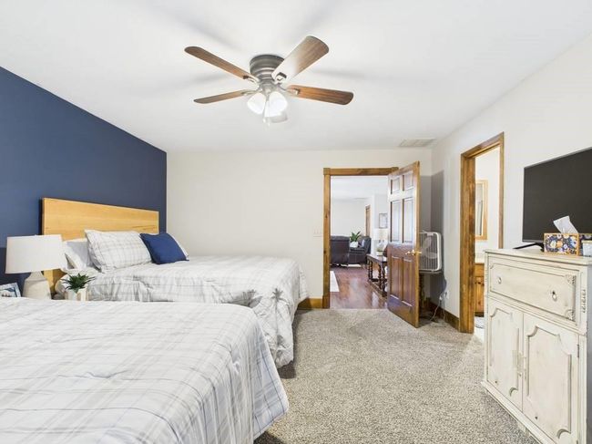 Primary Bedroom with baseboards, light colored carpet, ceiling fan, and visible vents located on main level | Image 24