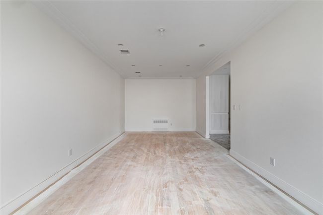 Unfurnished room with baseboards, light wood-style flooring, visible vents, and ornamental molding | Image 14