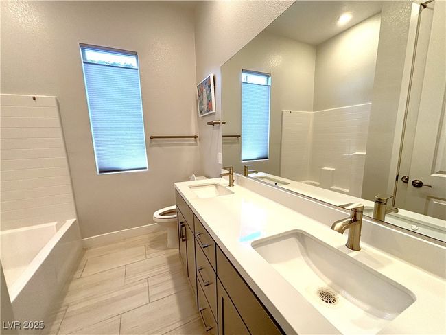Bathroom featuring toilet, a sink, and a tub | Image 29