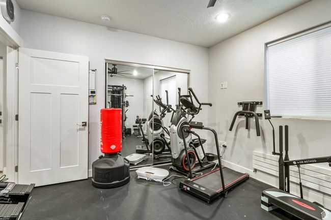 Exercise room featuring a ceiling fan and a textured ceiling | Image 86