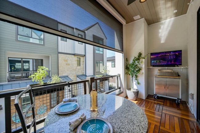 Covered patio features solar shade that can span floor to ceiling providing privacy and protection from bugs! | Image 18