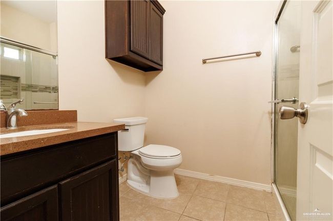 Full bathroom with a shower with door, vanity, and tile patterned flooring | Image 7