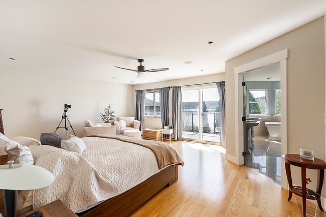 Bedroom with access to outside, light wood-style floors, a ceiling fan, and a water view | Image 18