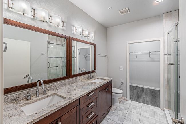 Bathroom featuring a stall shower, a spacious closet, and double vanity | Image 14