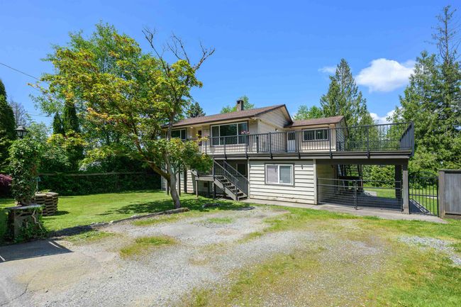 Back of house with stairway, a wooden deck, and a chimney | Image 4