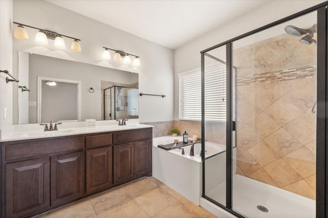 Full bathroom featuring double vanity, a garden tub, a sink, and a stall shower | Image 27