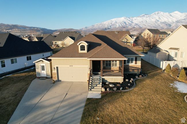 View of front of house featuring covered porch, a front lawn, a garage, and a mountain view | Image 44