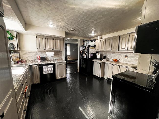 Kitchen featuring tasteful backsplash, dark wood finished floors, and black appliances | Image 19