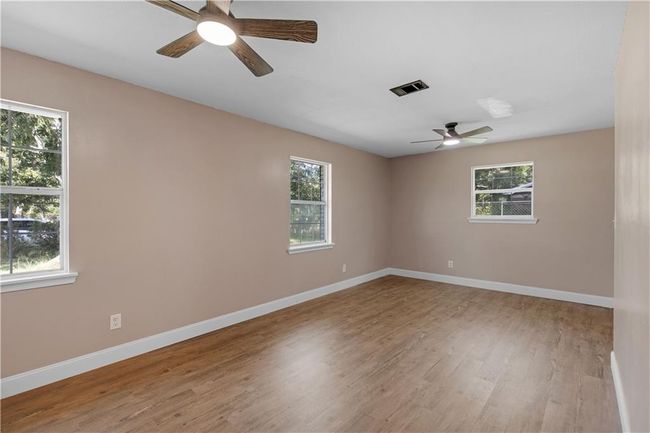 Spare room featuring visible vents, a ceiling fan, baseboards, and wood finished floors | Image 11