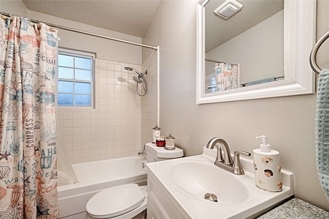 Bathroom featuring a textured ceiling, shower / bath combo with shower curtain, updated sink and​​‌​​​​‌​​‌‌​‌‌​​​‌‌​​‌‌​‌​​​​​‌ vanity | Image 19