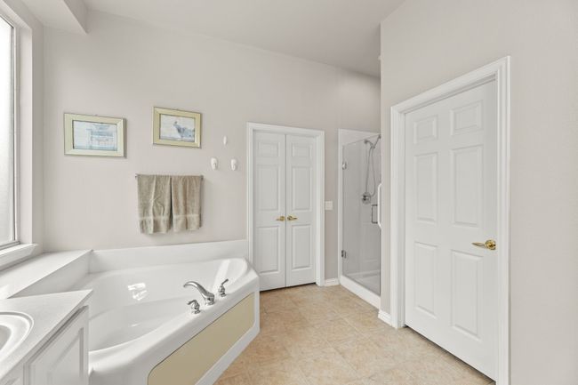 Full bathroom with a shower stall, a bath, vanity, and tile patterned flooring | Image 32