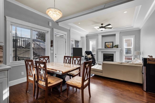 Dining room featuring a tray ceiling, plenty of natural light, dark wood-style floors, a ceiling fan, and ornamental molding | Image 14