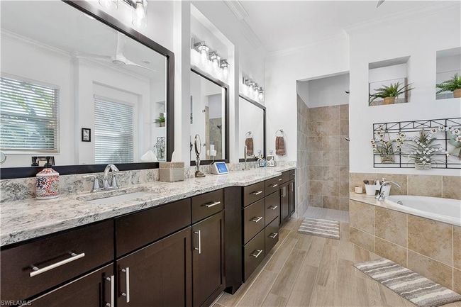 Full bathroom featuring crown molding, walk in shower, double vanity, a bath, and a sink | Image 48