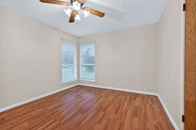 Spare room with a textured ceiling, light wood finished floors, and ceiling fan | Image 17