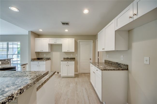 Kitchen with stone counters, white cabinetry, visible vents, and recessed lighting | Image 27