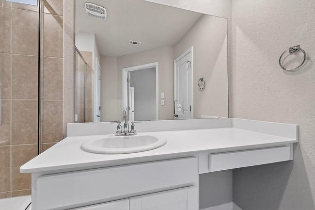 Bathroom featuring vanity and tiled shower | Image 21
