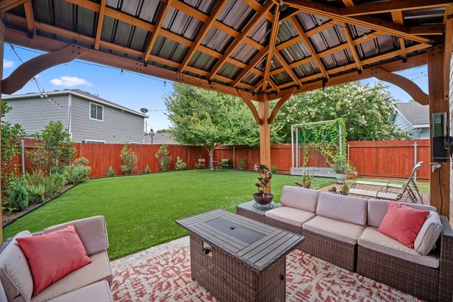 Fenced backyard with an outdoor living space, a patio area, and a gazebo | Image 12