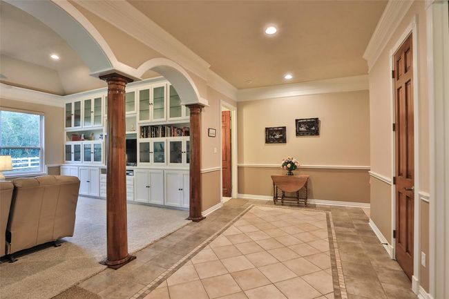 Welcome to this extra wide foyer! Notice the double crown molding, arches, wooden columns, and chair railing. The original owner, this seller took pride un the building process. | Image 11