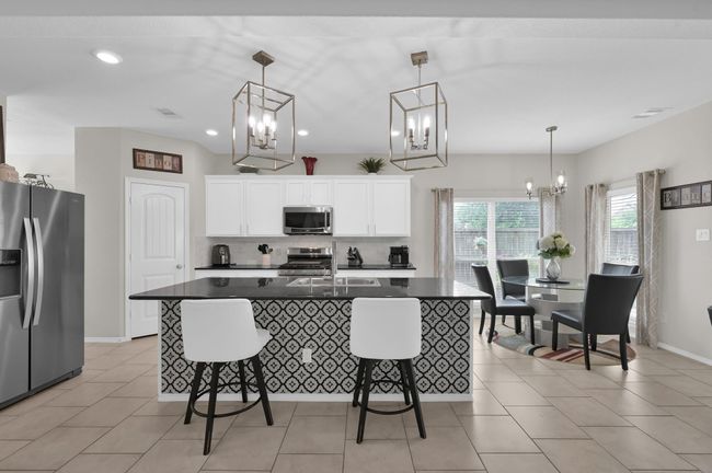 The kitchen opens to a cheerful breakfast area surrounded by windows, perfect for sipping morning coffee while enjoying the view of the backyard oasis (more on that later!) | Image 9