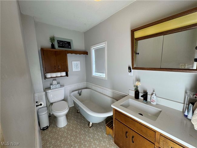 First floor full bath with vanity, a freestanding bath, wainscoting, and tile patterned floors | Image 20