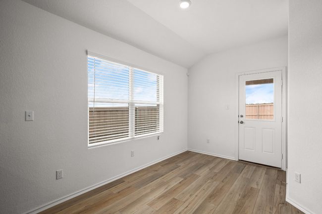 Empty room featuring healthy amount of natural light, light wood-style flooring, lofted ceiling, and baseboards | Image 12