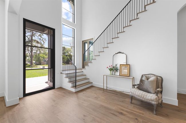 This bright and inviting entryway is filled with natural light from expansive windows, highlighting the soaring ceilings and elegant design for a warm and welcoming first impression. | Image 4
