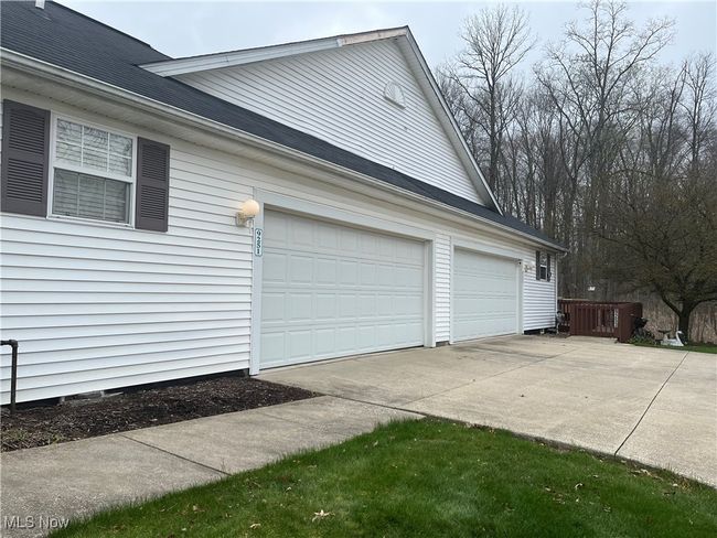 View of property featuring garage, driveway and walkway to the front of the house. | Image 34