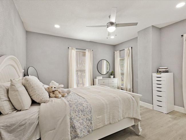 Bedroom with light wood-type flooring, a ceiling fan, recessed lighting, and baseboards | Image 25