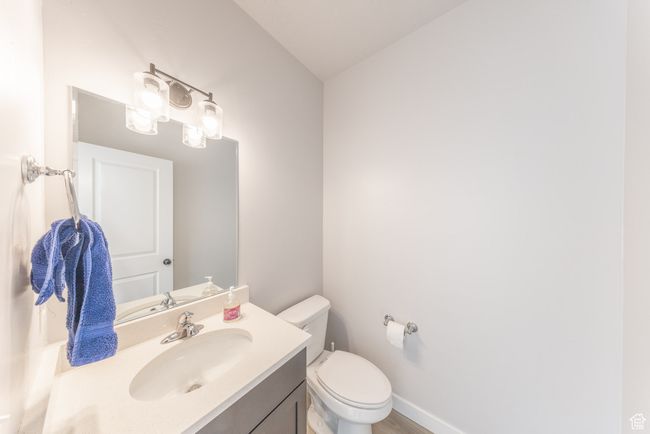 Bathroom featuring vanity, toilet, wood finished floors, and baseboards | Image 11