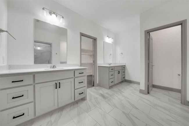 Bathroom with a shower, two vanities, marble finish floor, and a sink | Image 23