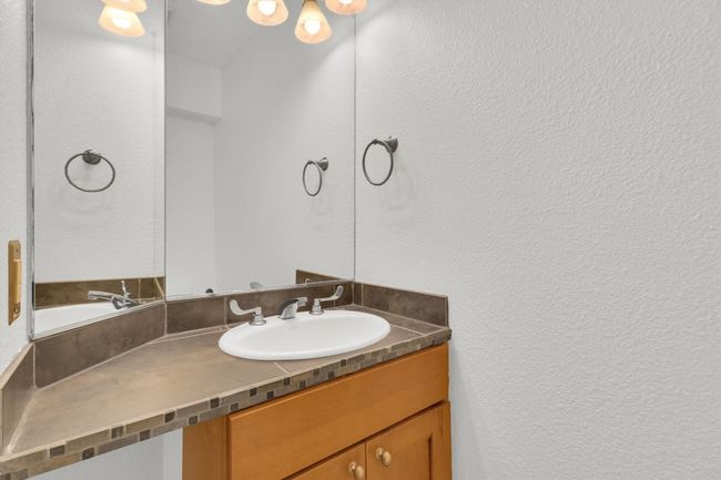 Bathroom with a textured wall and vanity | Image 15