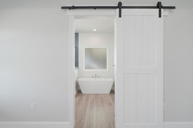 Bathroom with baseboards, a freestanding tub, and wood finished floors | Image 21