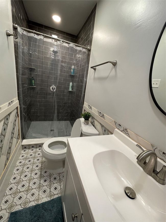 Full bathroom featuring vanity, a shower stall, and light tile patterned floors | Image 19