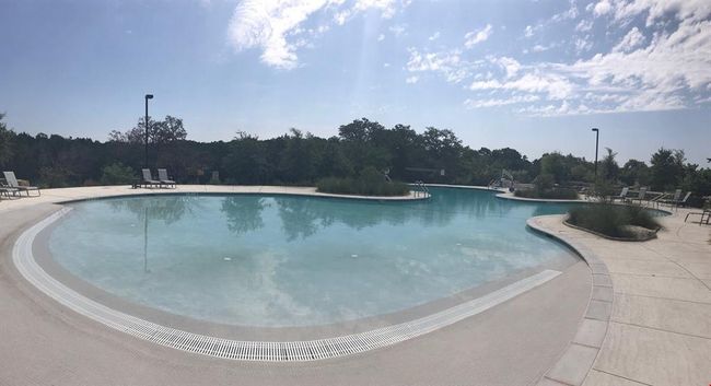 Community pool featuring a view of trees and a patio area | Image 30