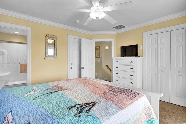 Carpeted bedroom with crown molding, connected bathroom, and ceiling fan | Image 18