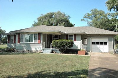 Ranch-style home with a front yard and a garage | Image 1