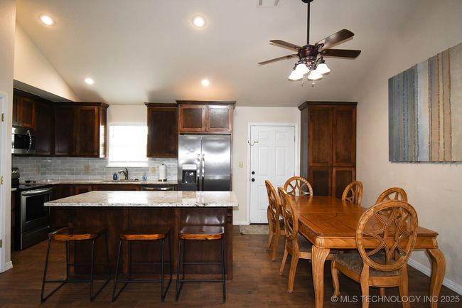 Kitchen with appliances with stainless steel finishes, lofted ceiling, baseboards, tasteful backsplash, and dark wood-style floors | Image 12