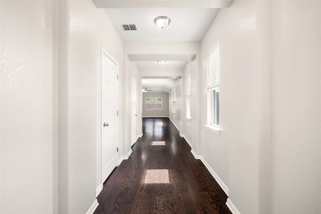 Hallway featuring dark wood finished floors and healthy amount of natural light | Image 9
