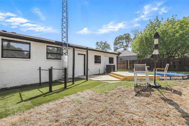 Rear view of property with a deck, cooling unit, and brick siding | Image 38