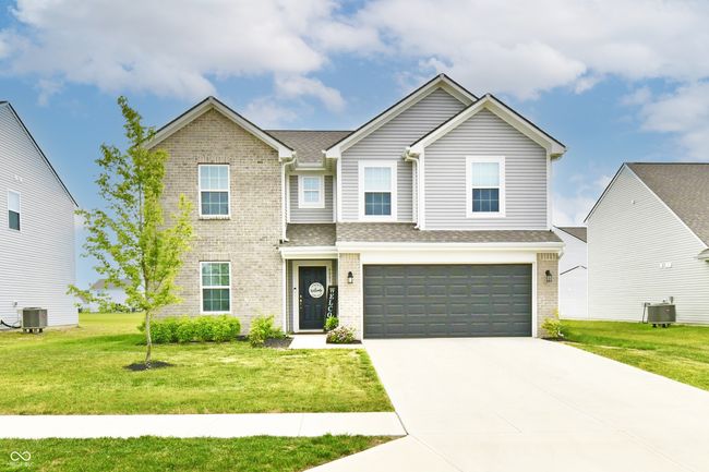view of front of house featuring brick siding, a garage, a front lawn, and concrete driveway | Image 72