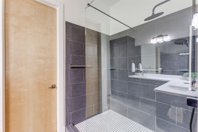 Bathroom featuring a tile shower and double vanity | Image 17